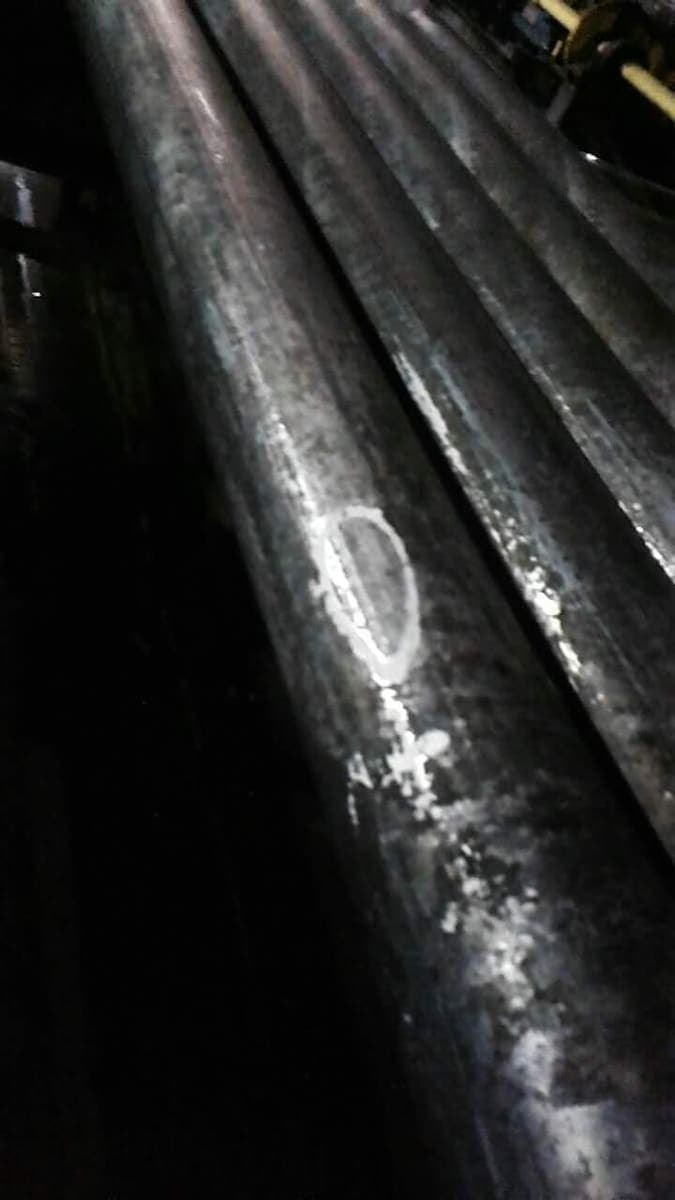 Industrial tubular pipes marked for quality control on the factory floor
