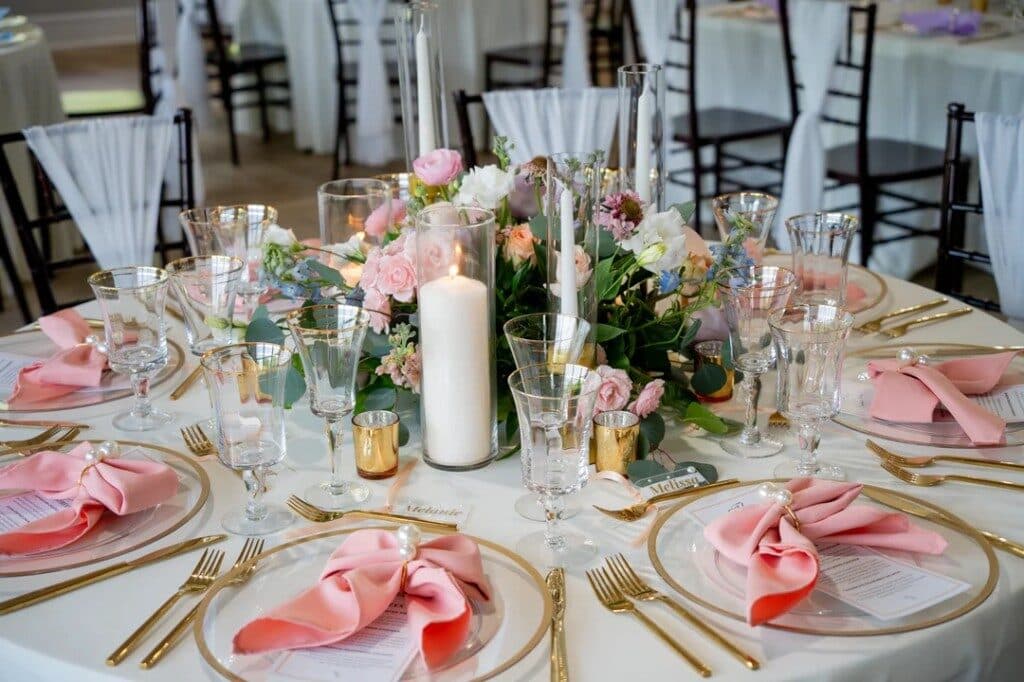 Styled wedding tablescape with florals, candles, and gold place settings